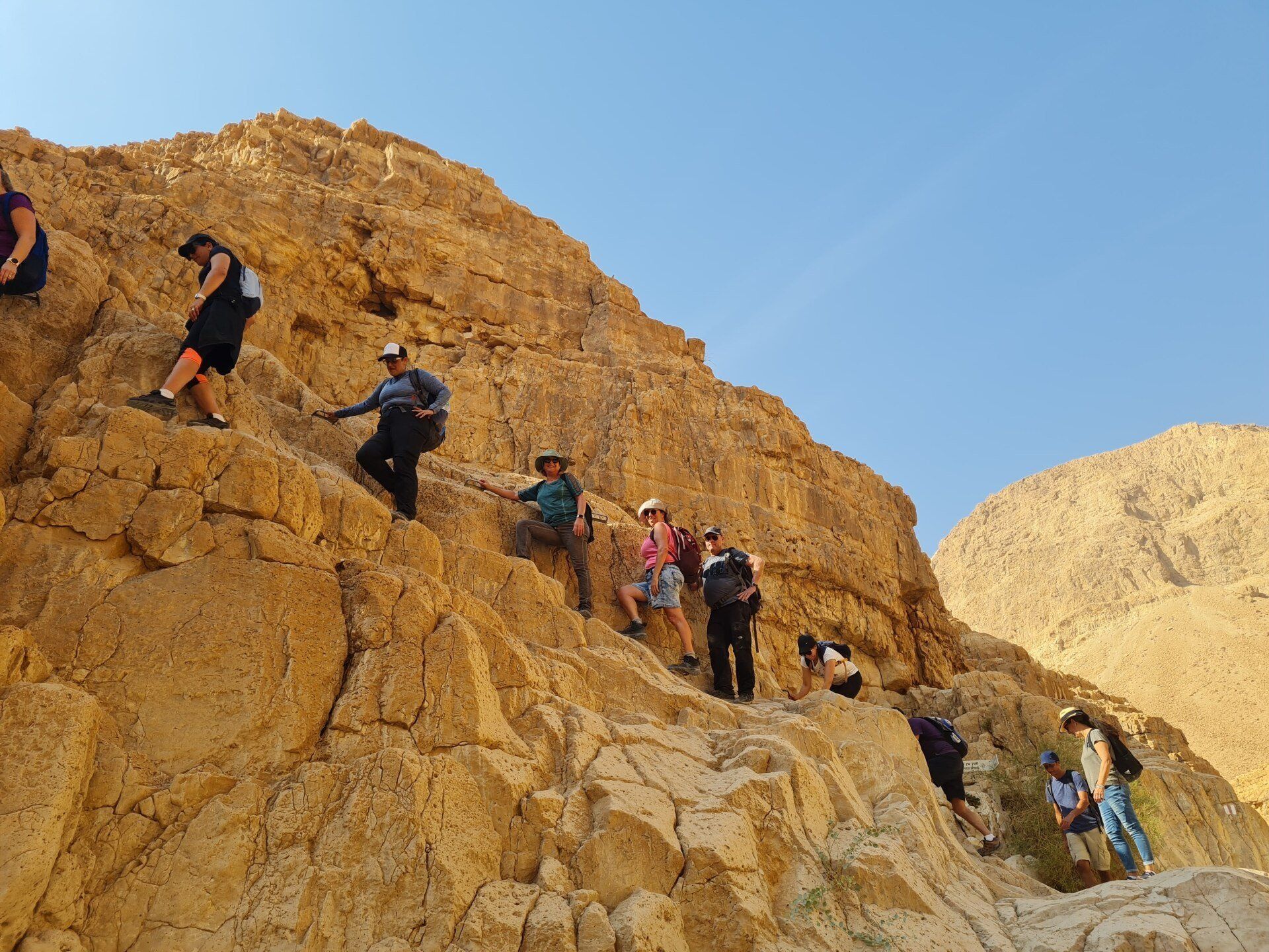 קבוצת אנשים מטפסת במעלה הר סלעי.