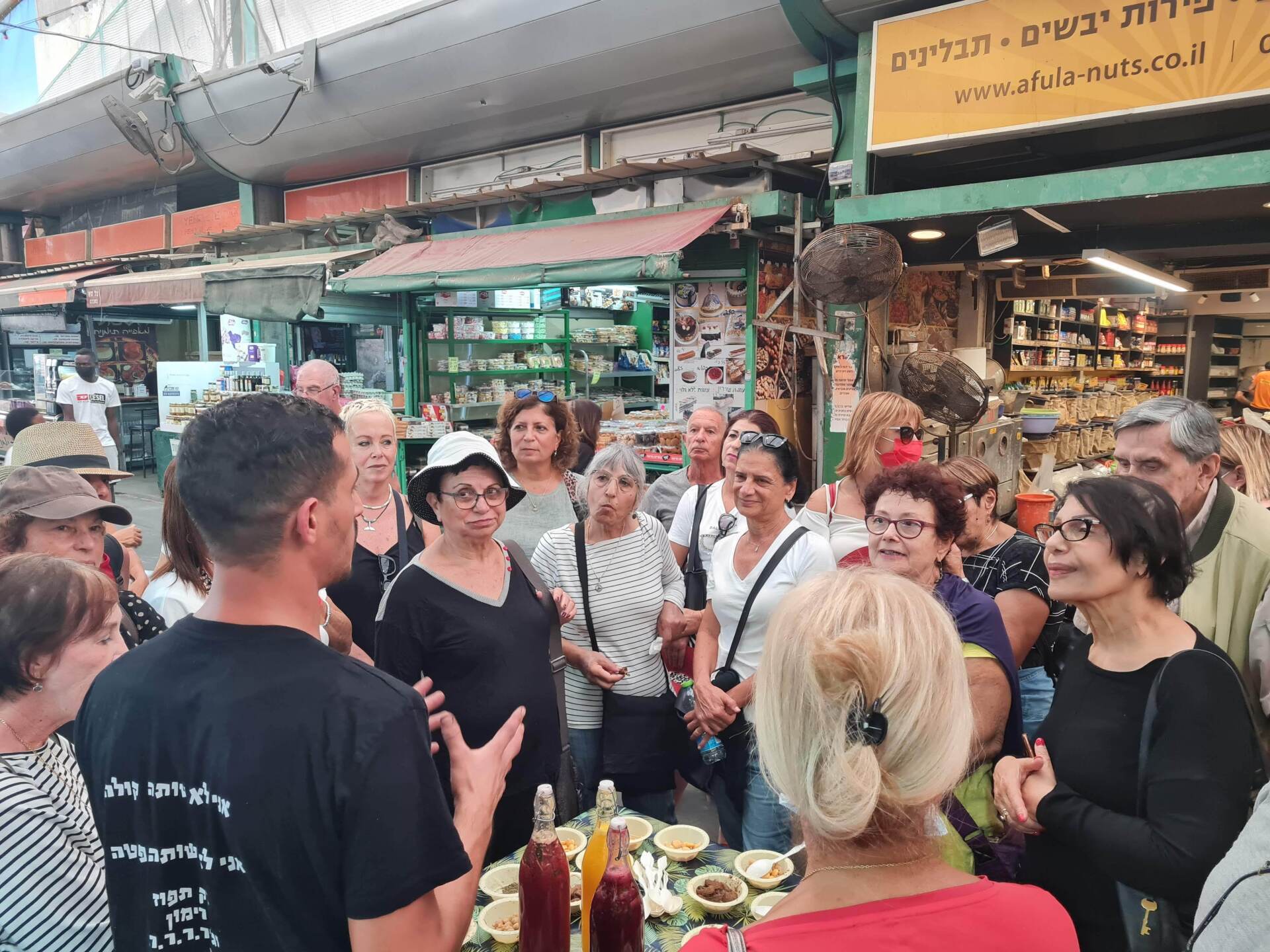 קבוצת אנשים עומדת סביב שולחן בשוק.