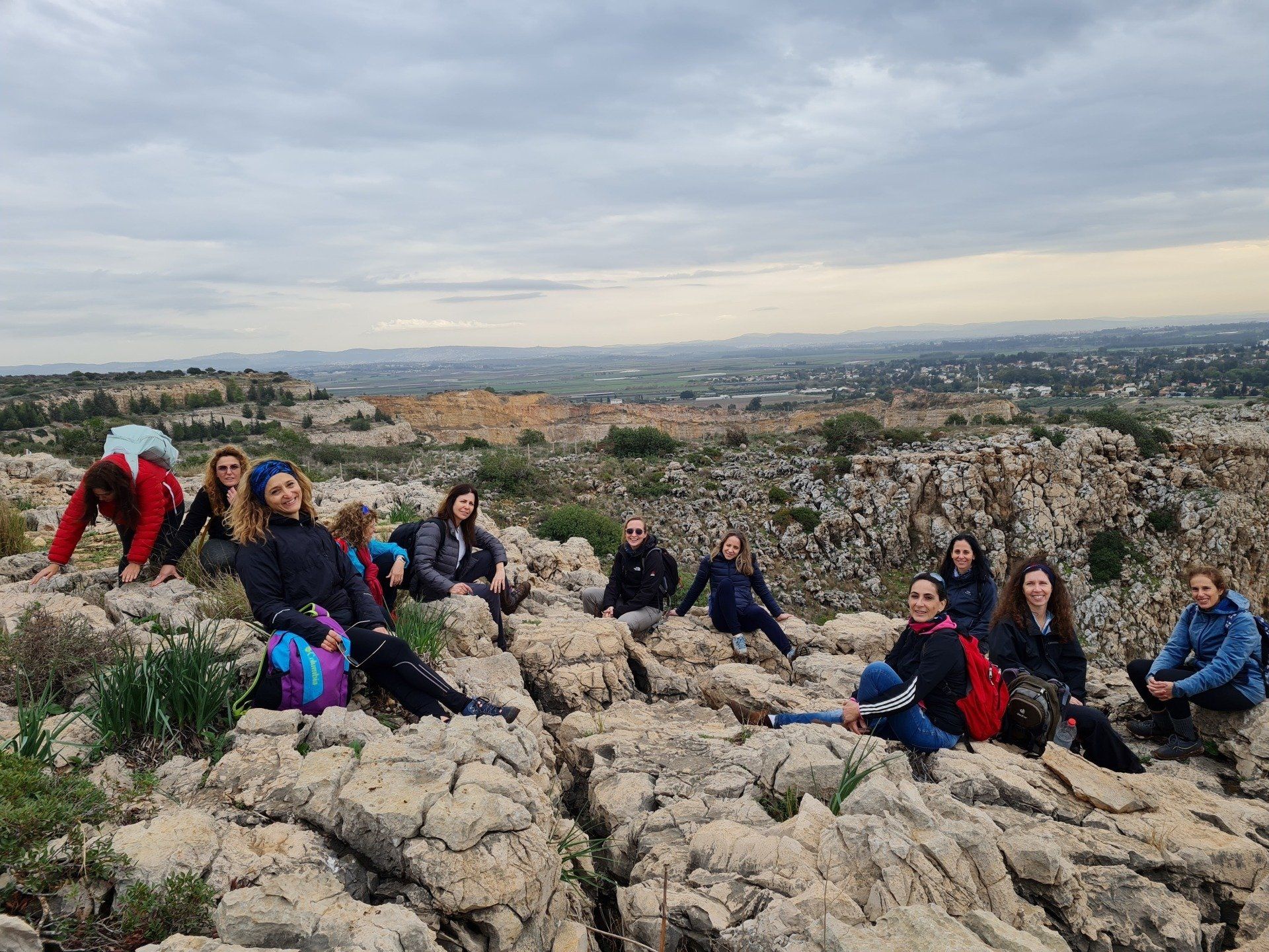 קבוצת אנשים יושבת על ראש גבעה סלעית.