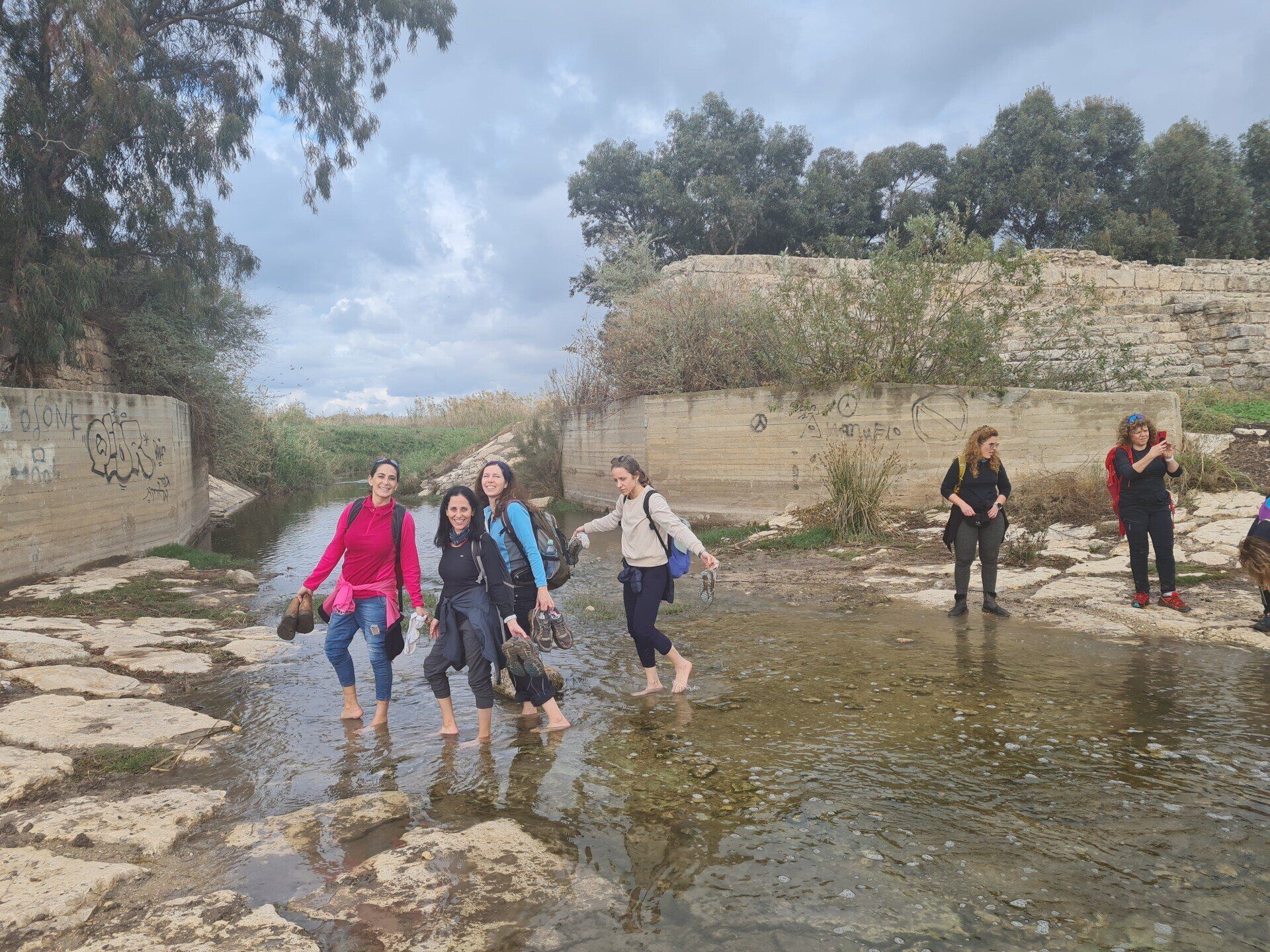 קבוצה של אנשים הולכים יחפים בנהר.