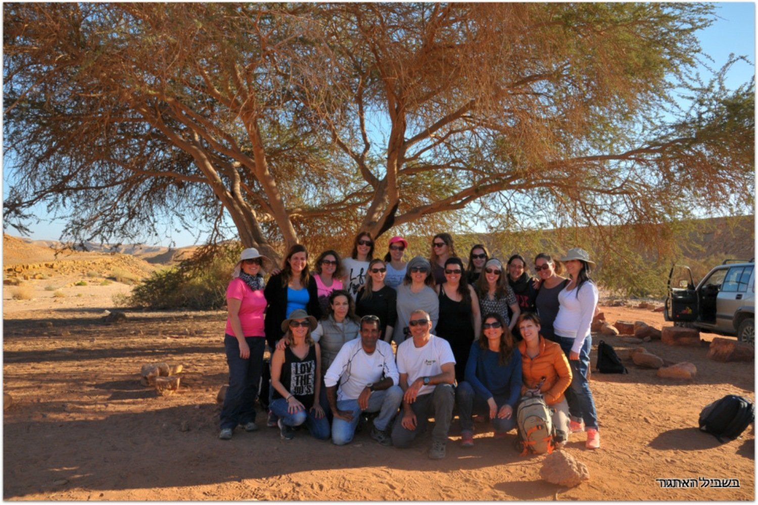 קבוצה של אנשים מצטלמים מתחת לעץ