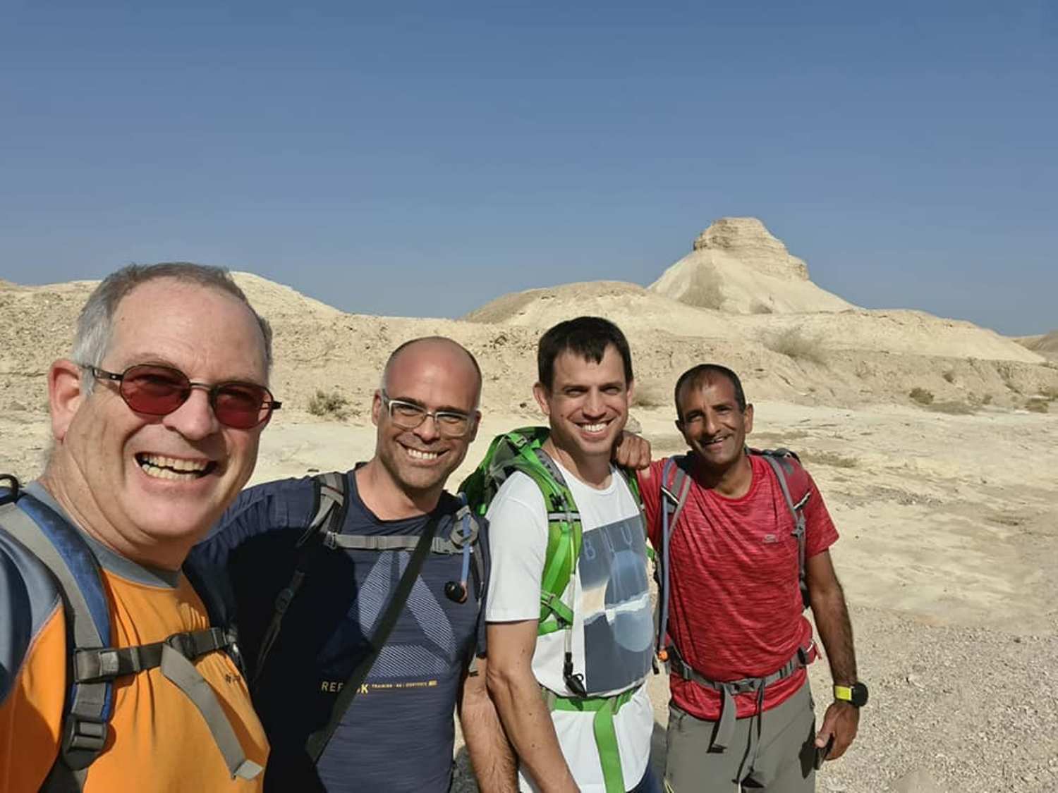 קבוצת גברים מצטלמת במדבר.