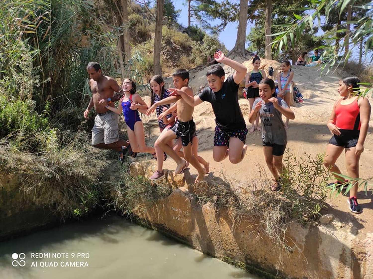 קבוצת ילדים קופצת לנהר.