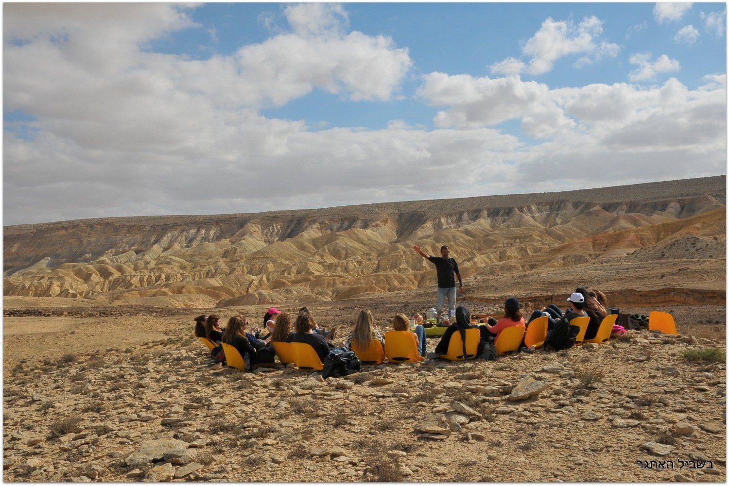 קבוצת אנשים יושבת במעגל במדבר