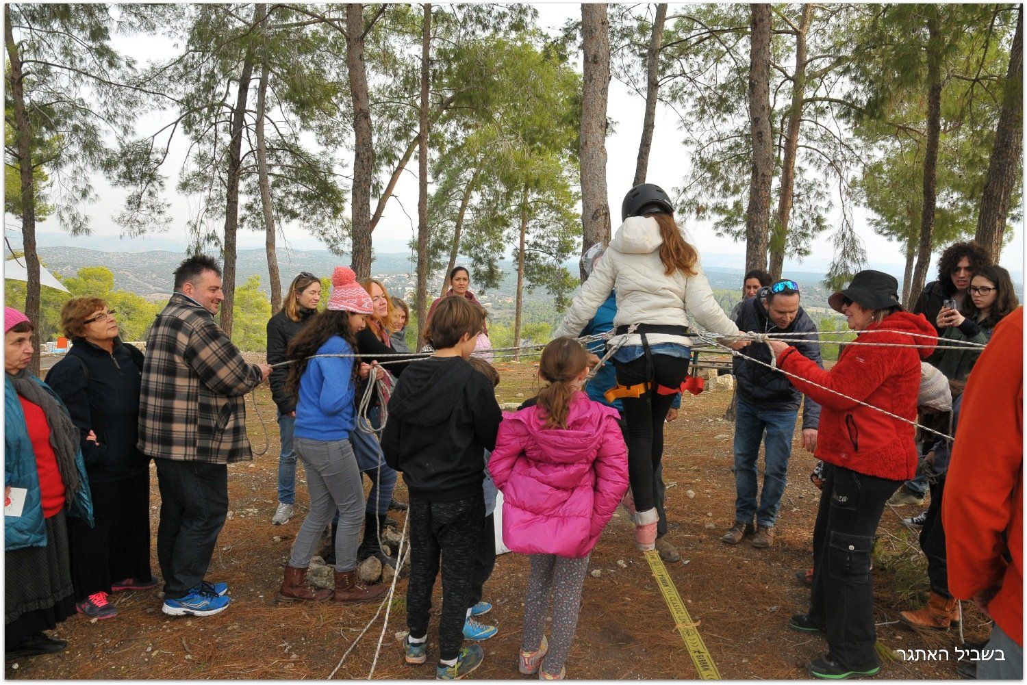 קבוצה של אנשים משחקת משחק ביער.