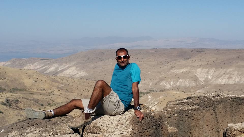 אדם יושב על סלע במדבר.