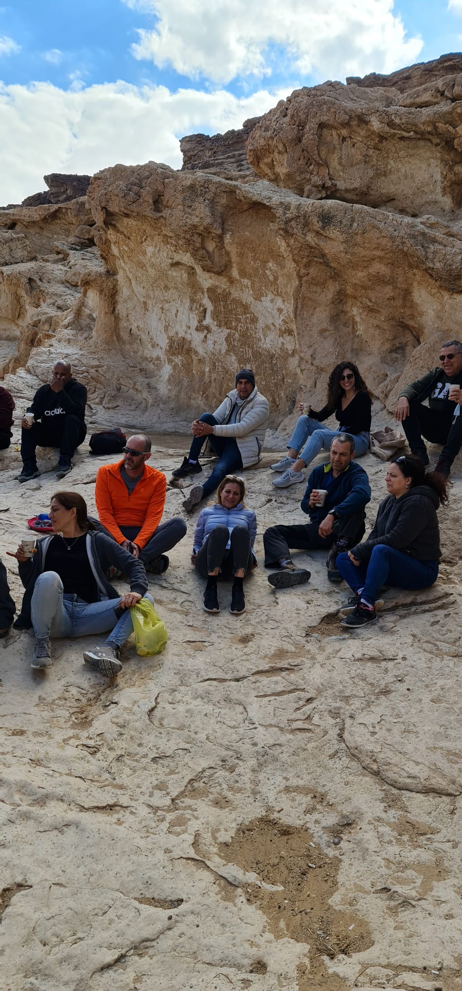 קבוצת אנשים יושבת על האדמה במדבר.