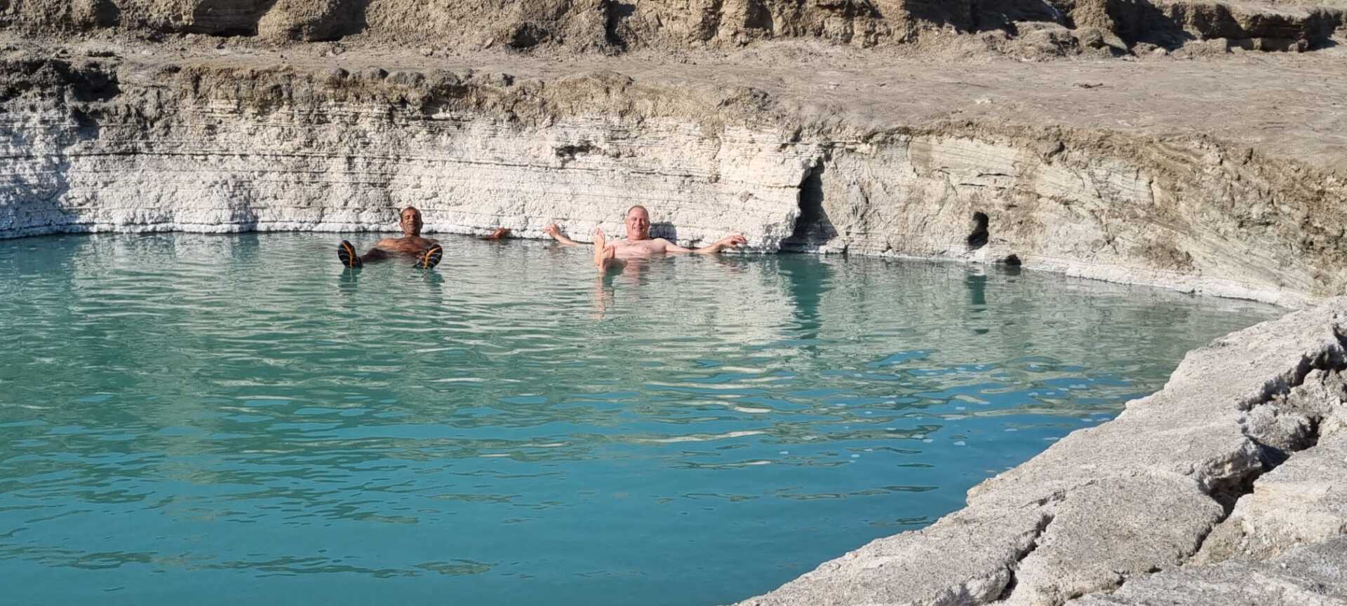 קבוצה של אנשים שוחה בתוך גוף מים גדול.