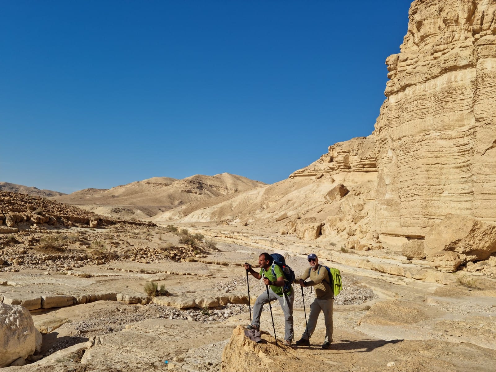 שני גברים מטיילים במדבר עם תרמילים.