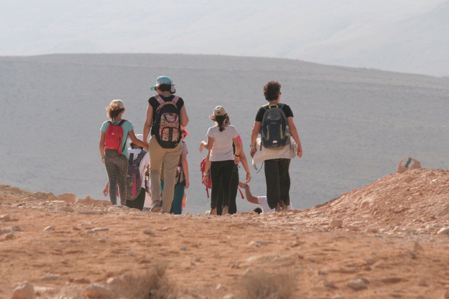 קבוצה של אנשים עם תרמילים מטיילת במדבר.