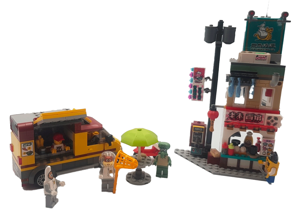 Camionnette et boutique LEGO avec figurines et table avec parasol.