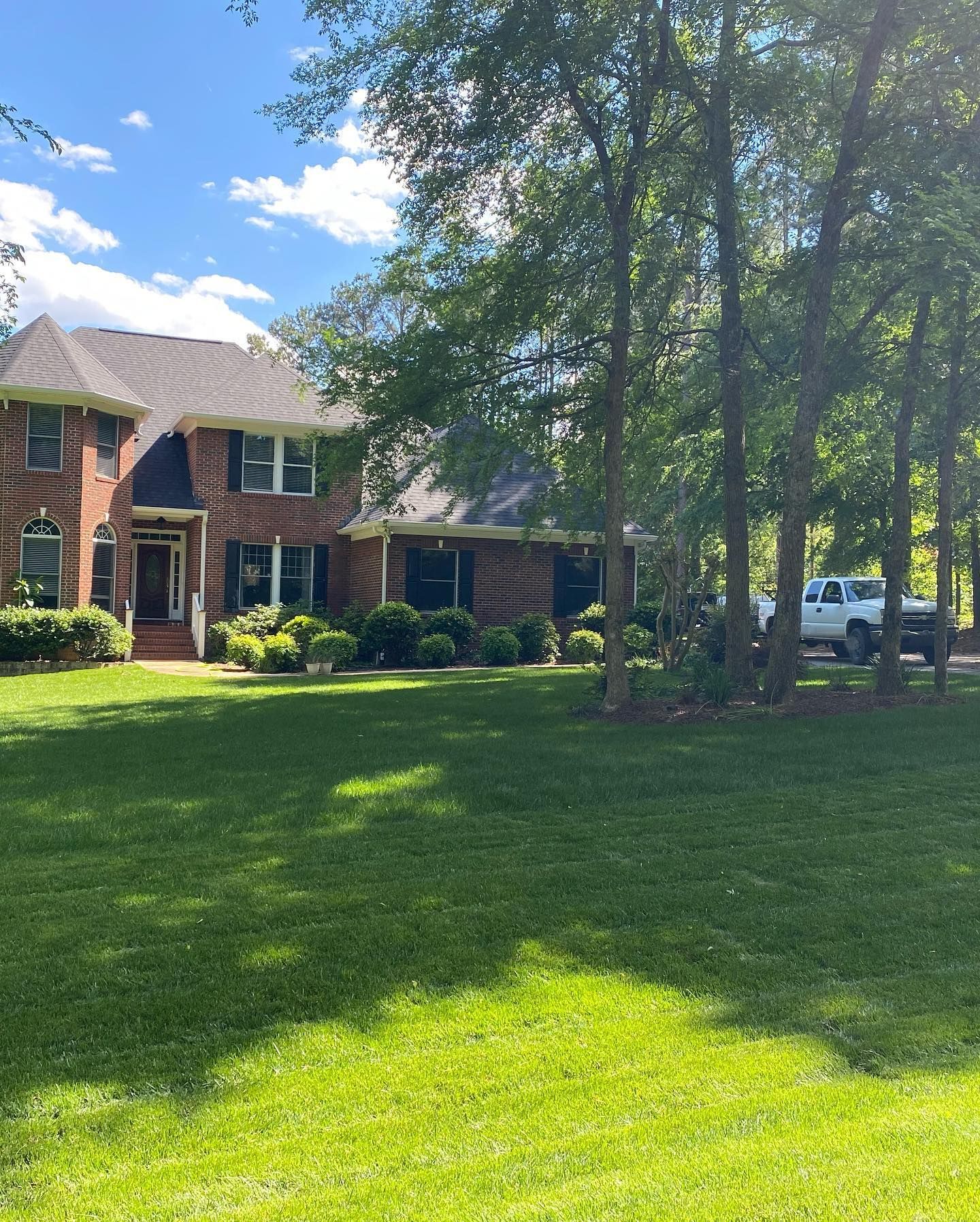 A large brick house with a large lawn in front of it