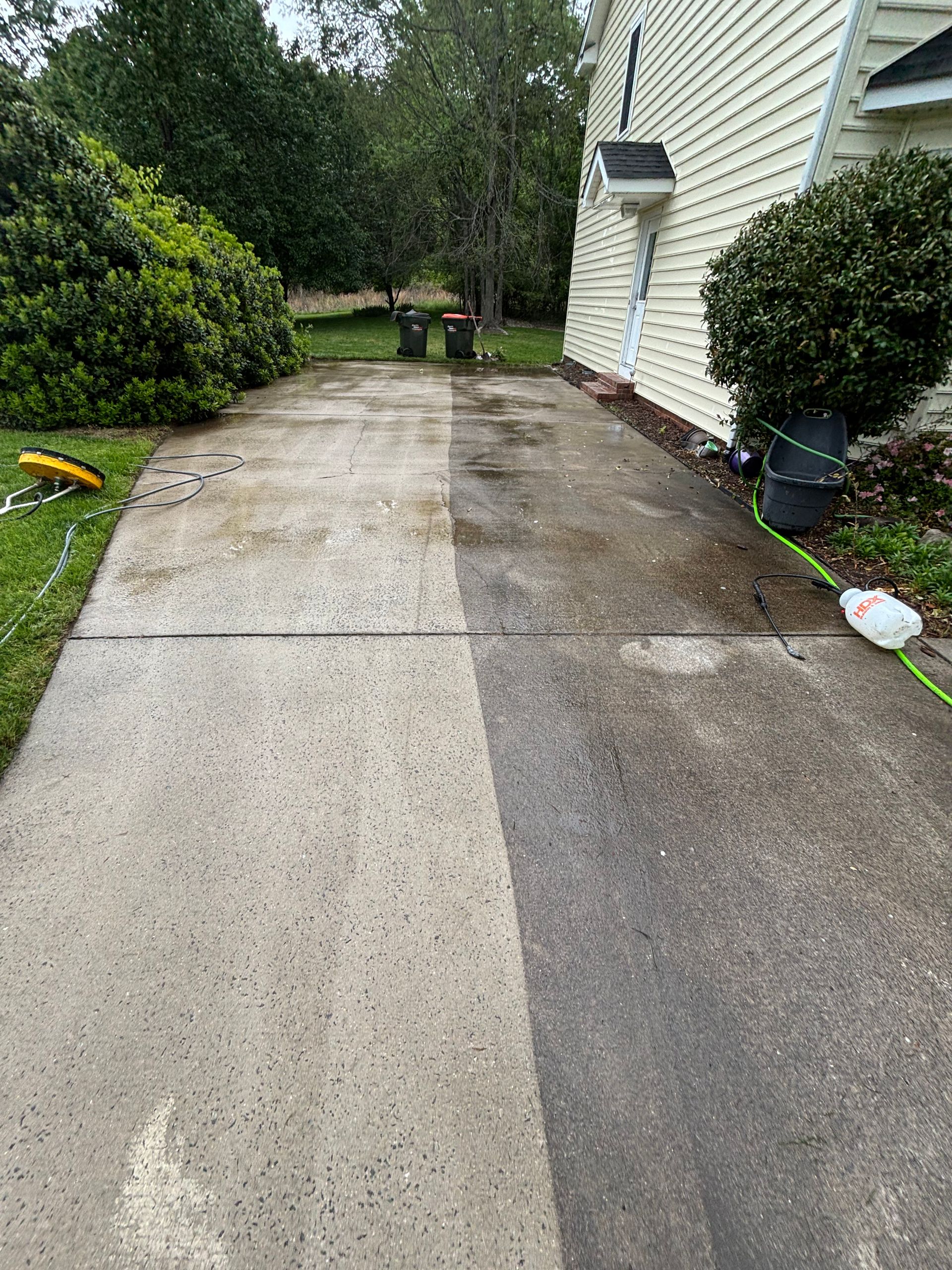 Driveway power washed, revealing a clean, light gray section next to the original dark gray.