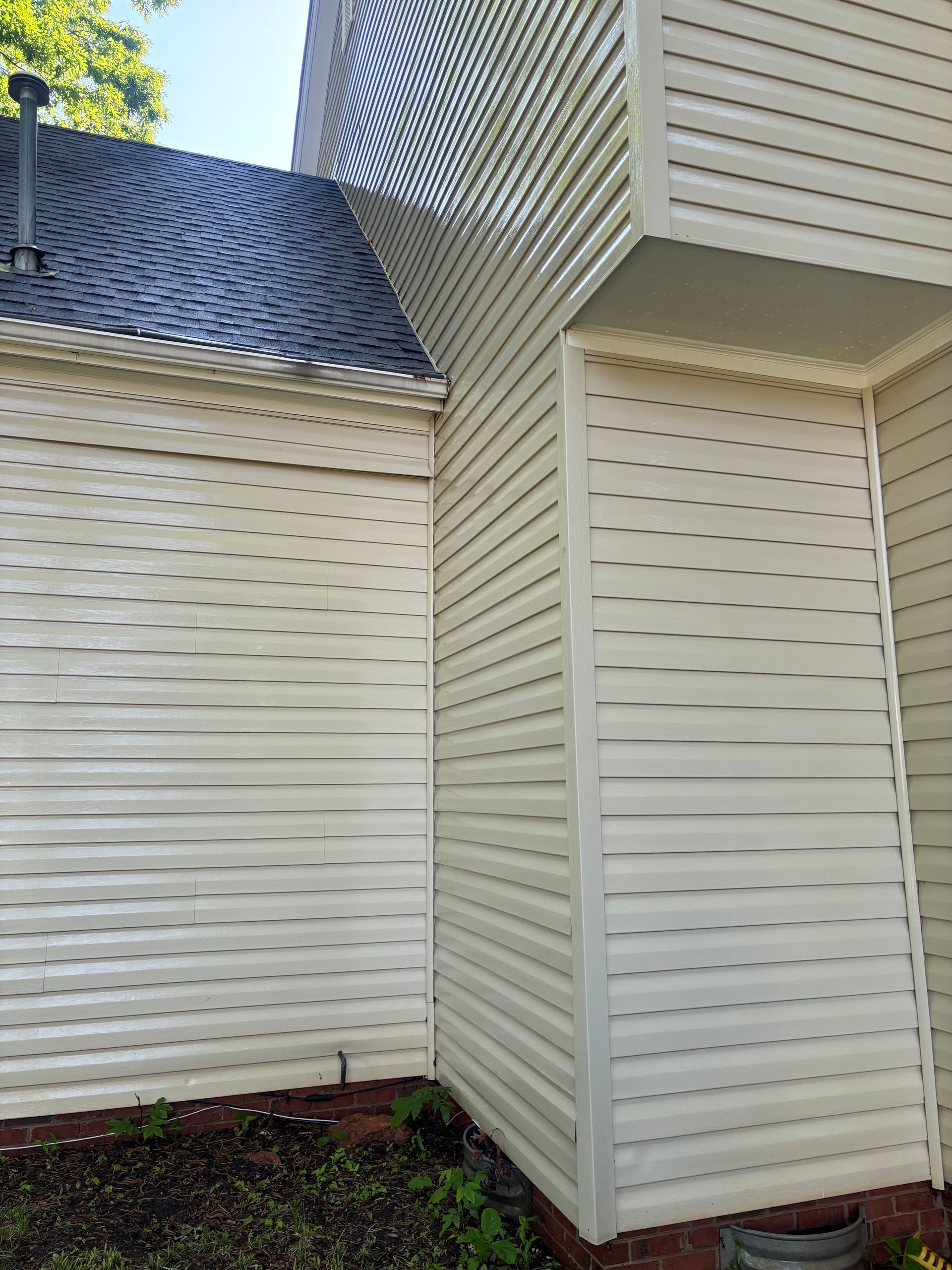 The side of a house with a wooden fence and a lot of windows.