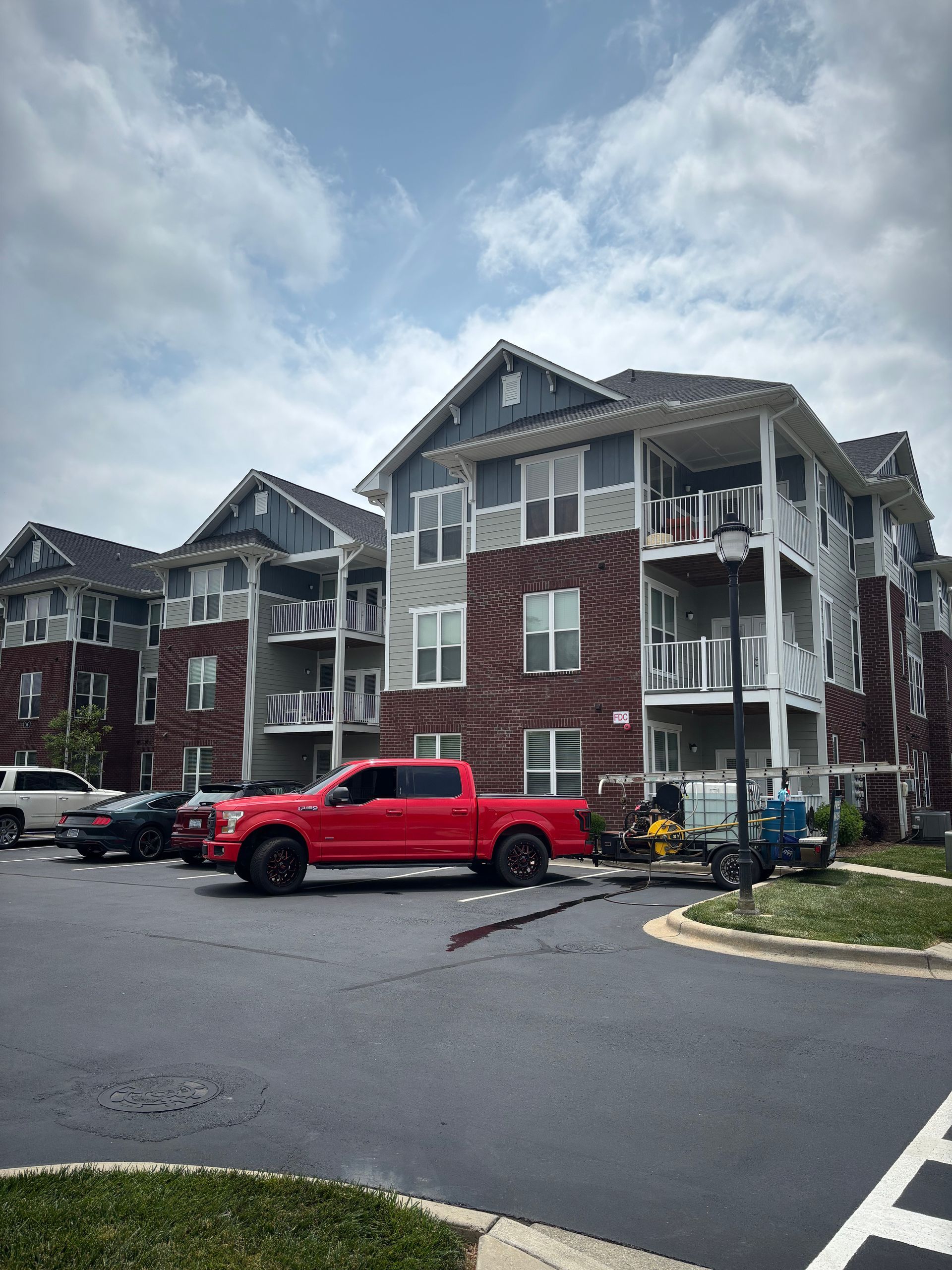 Apartment building with red truck parked in front on a cloudy day.