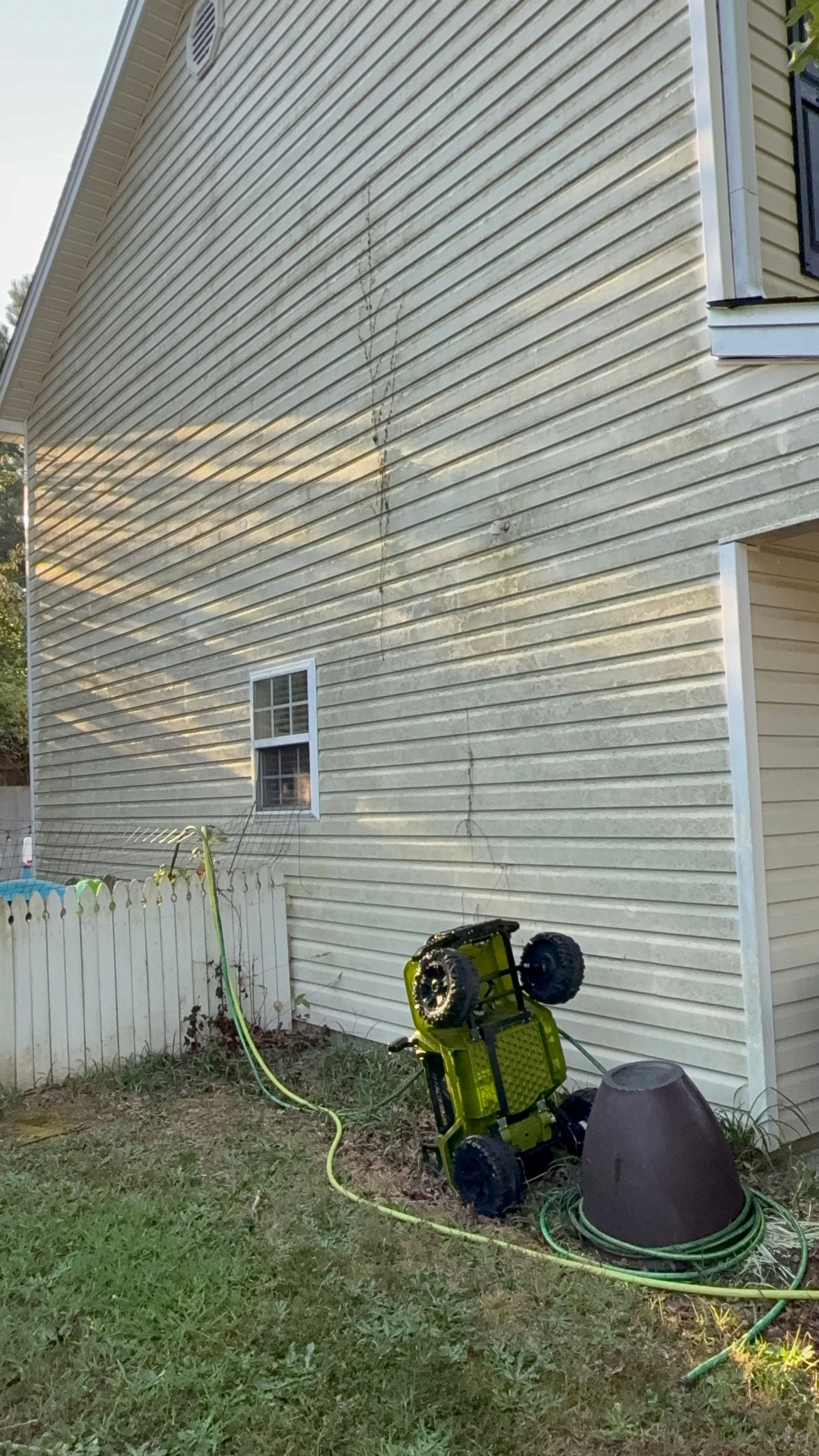 The back of a white house with a lot of stains on it.
