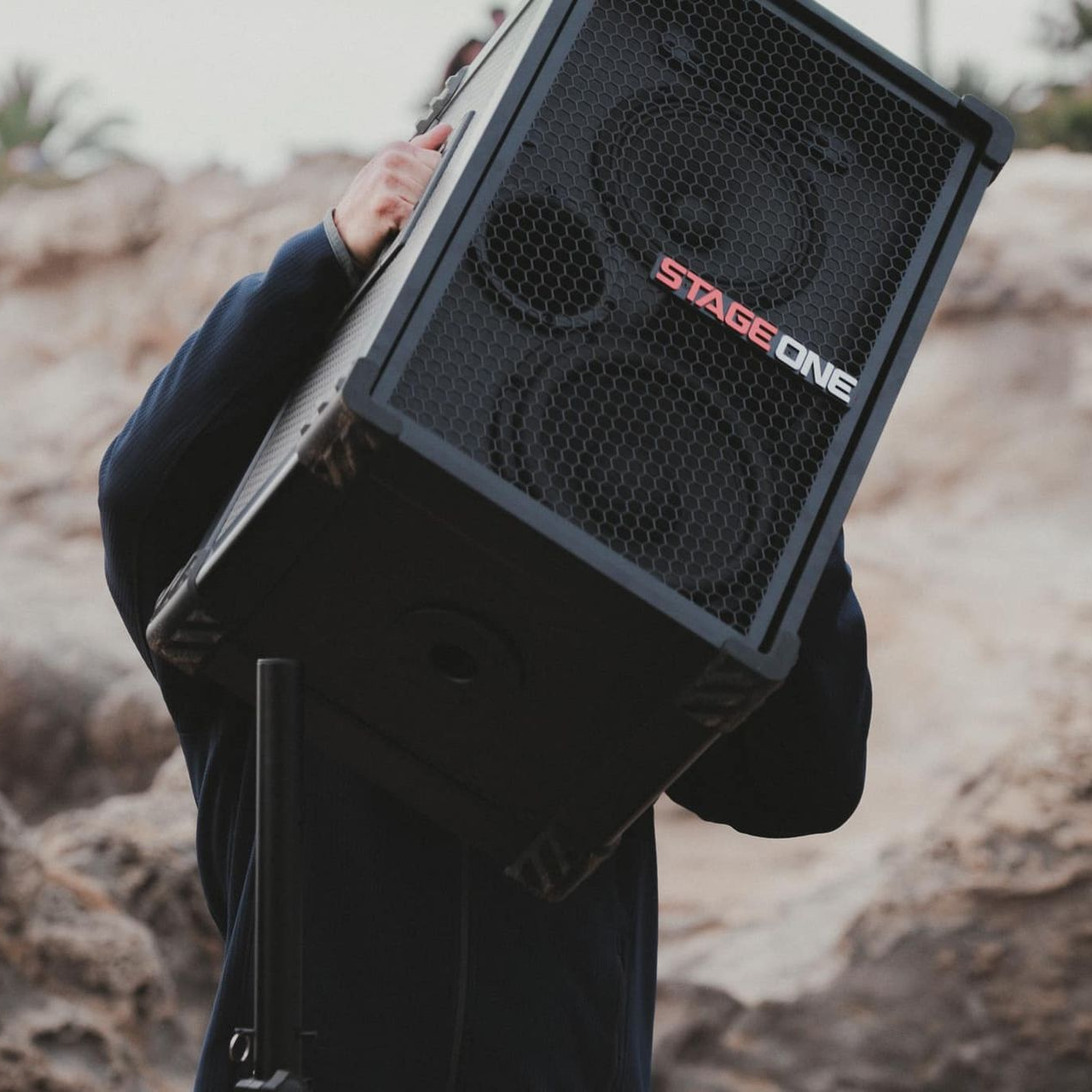 Person carrying a black speaker labeled 