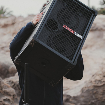 Person carrying a black speaker labeled 