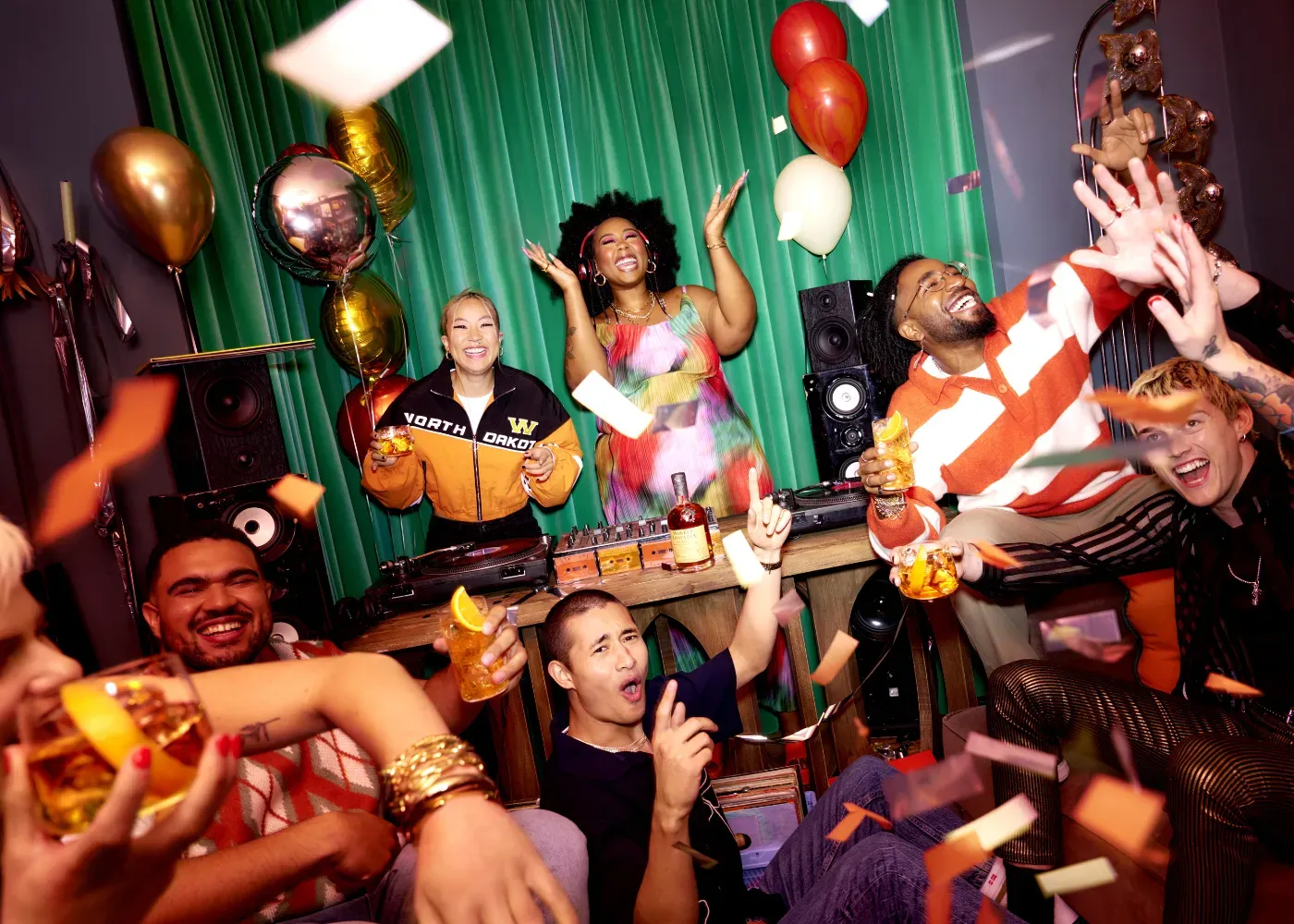 A group of people are having a party with balloons and confetti.