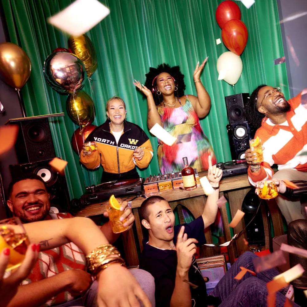 A group of people are having a party with balloons and confetti.