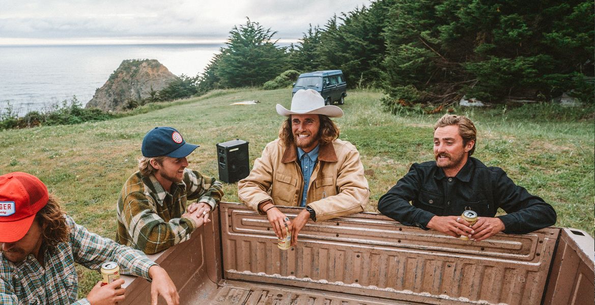 A group of men have a beer outside while listening to SOUNDBOKS 3 speaker
