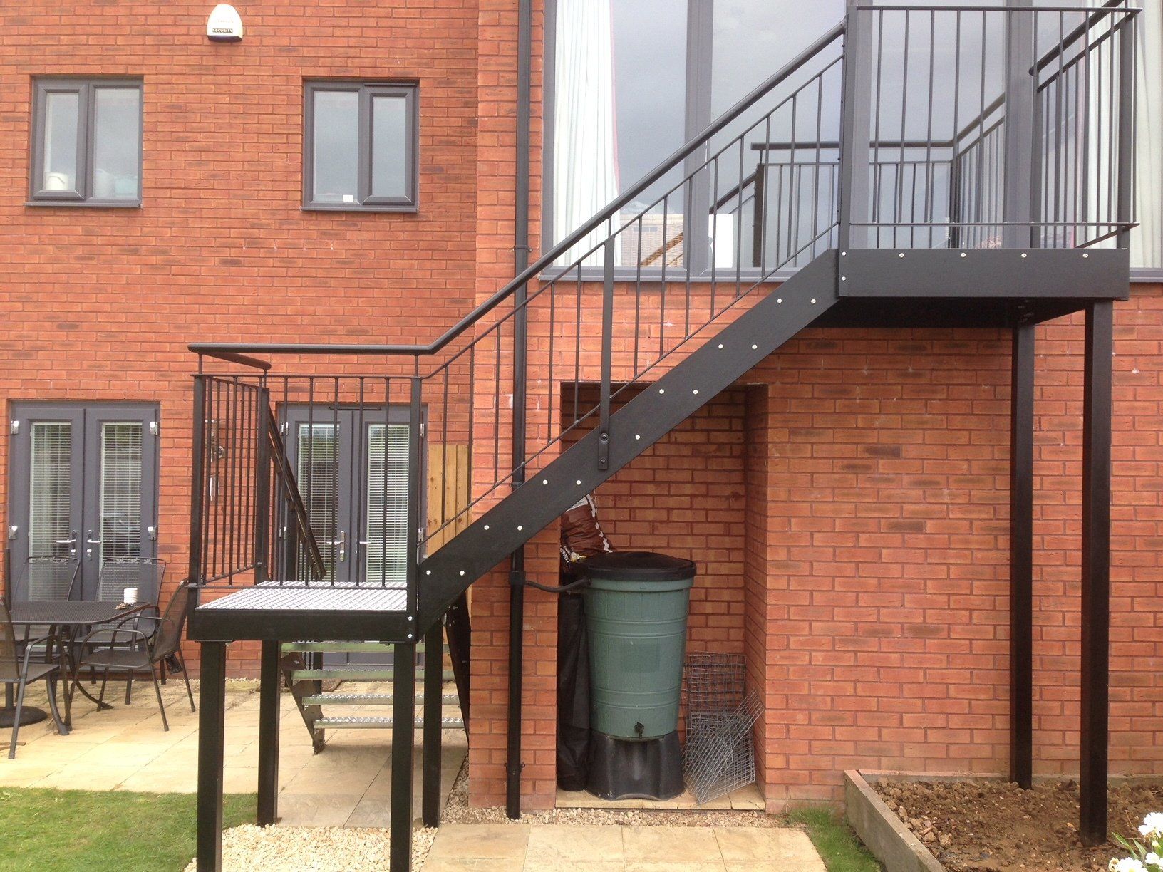 Black metal exterior staircase attached to a brick building.