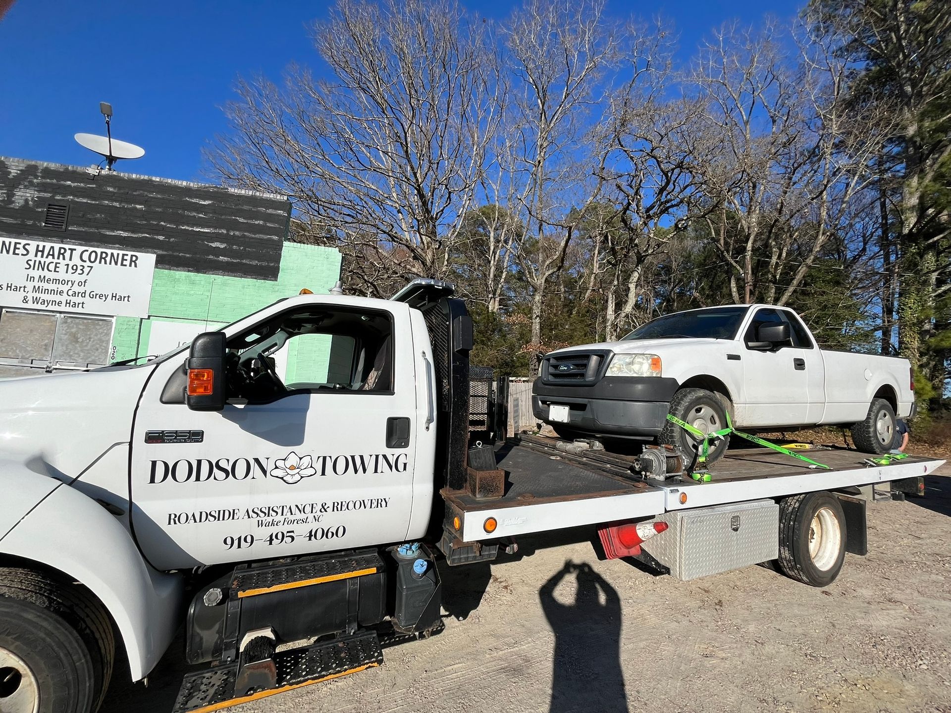 A tow truck with a white truck on the back of it