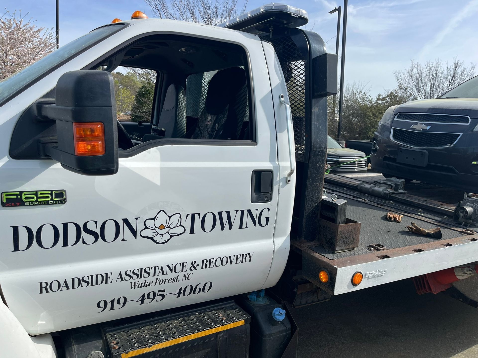 A white tow truck with the word dodson on it