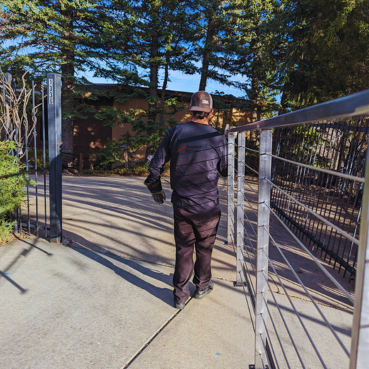 A man wearing a hat is walking across a bridge