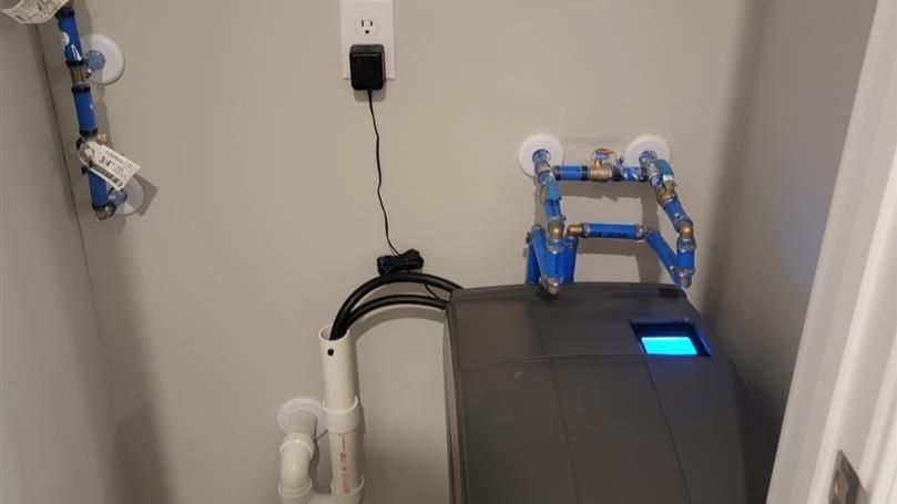 A machine is sitting in a closet next to a wall.