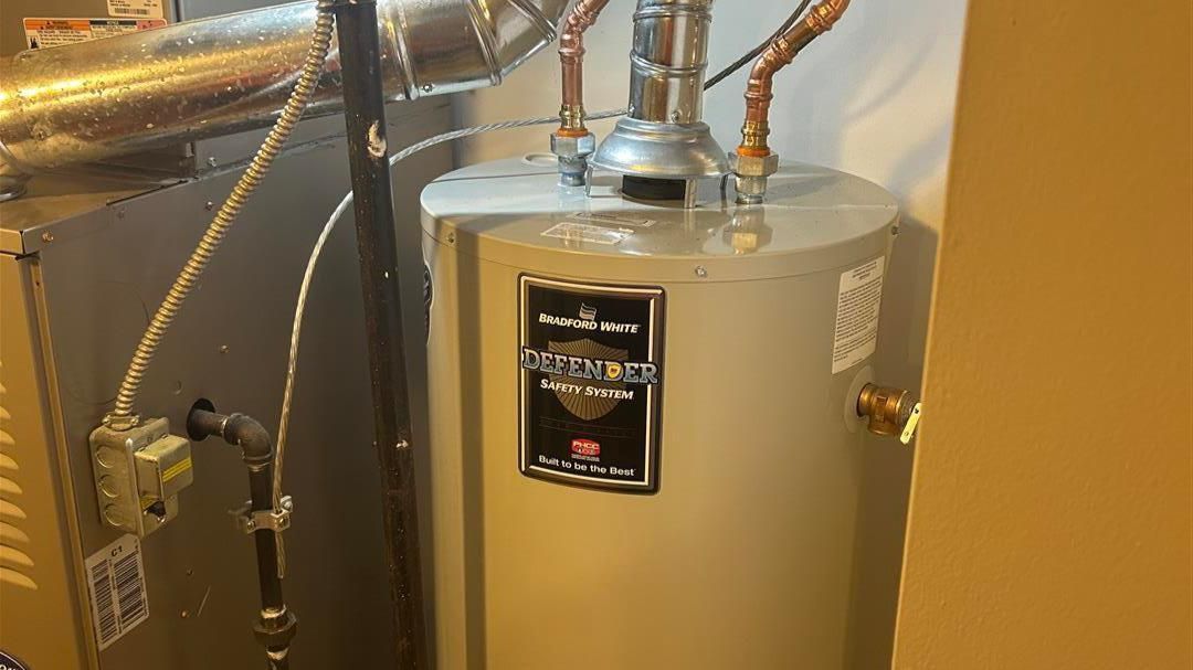 A water heater is sitting in a room next to a door.