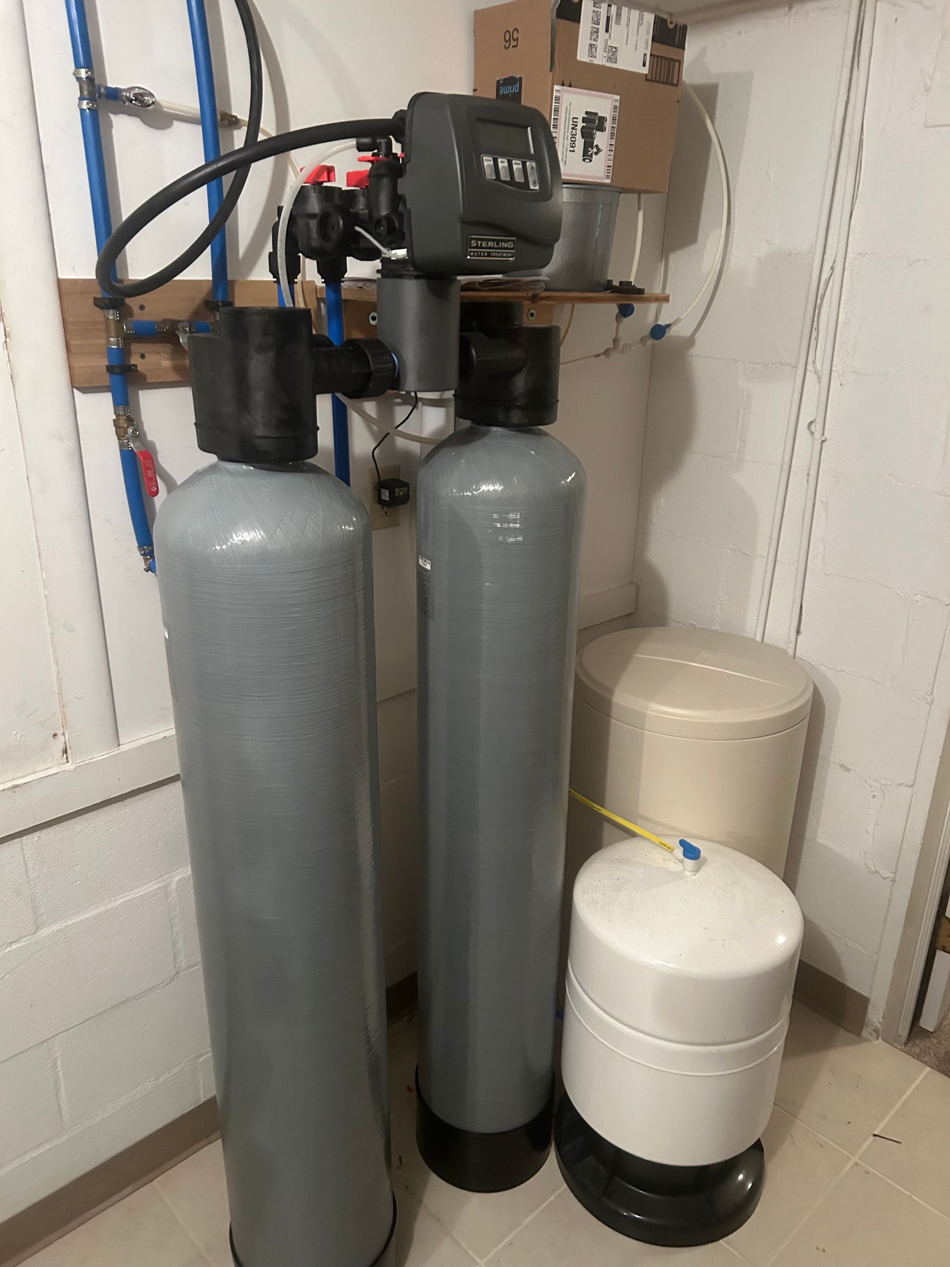 Two water filters are sitting next to each other in a room.