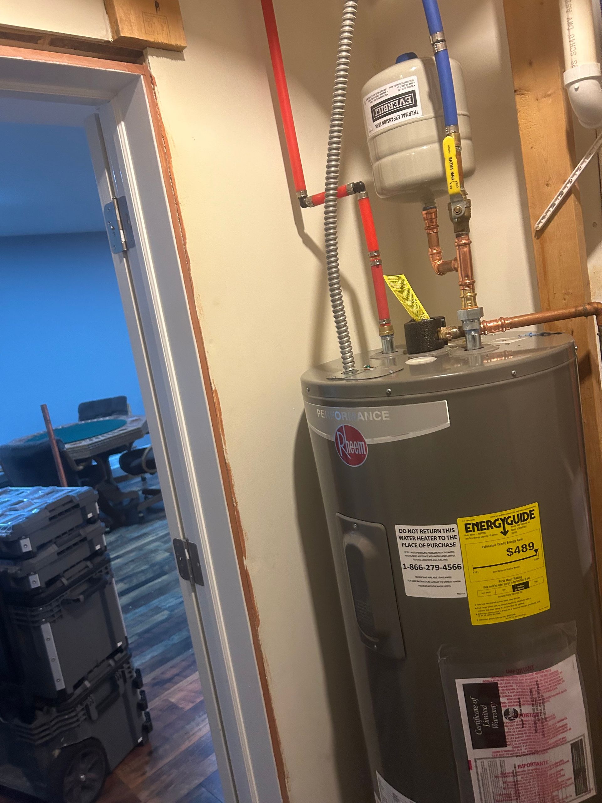 A water heater is sitting in a room next to a door.