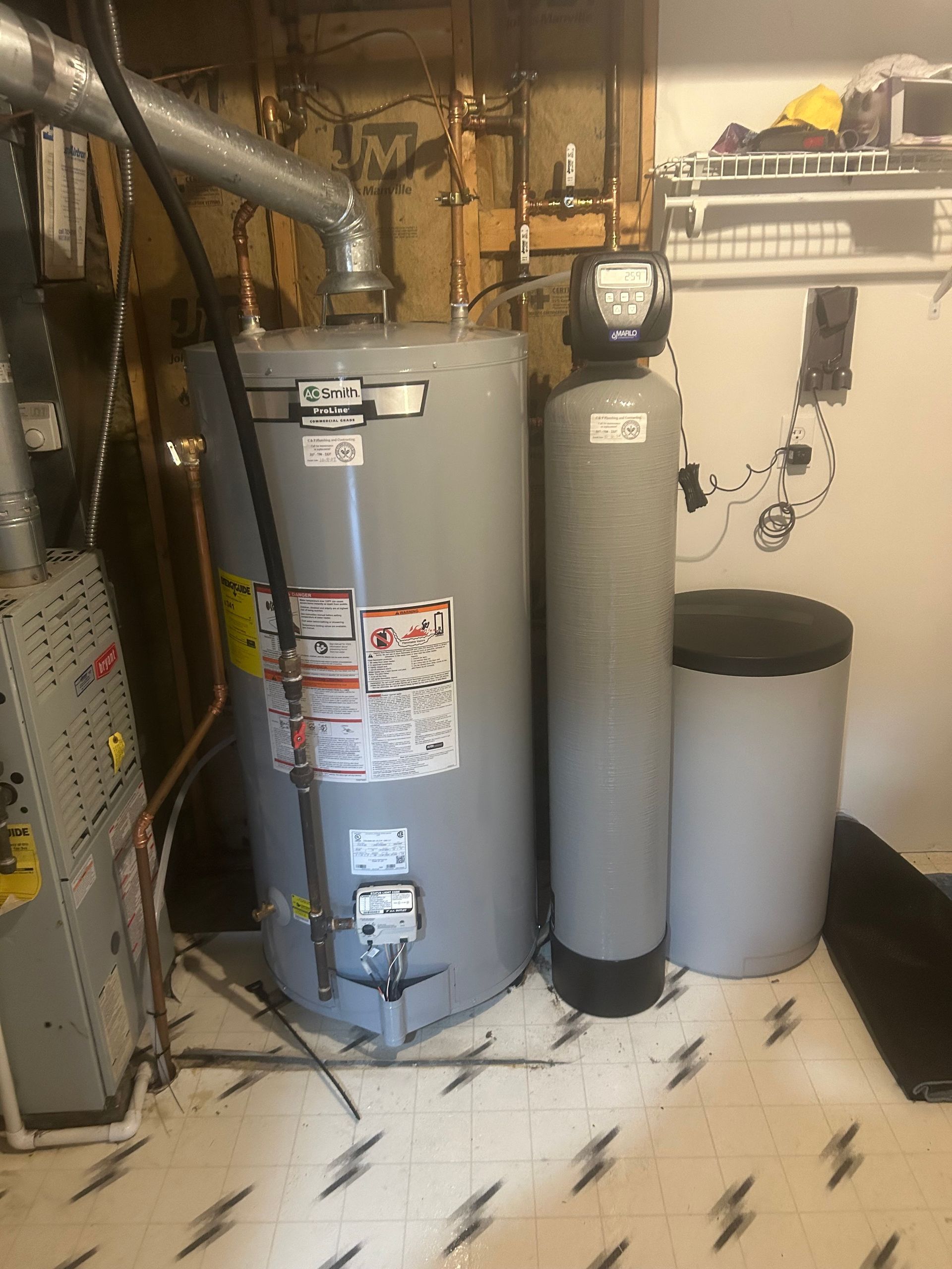 A water heater and a water filter are in a basement.