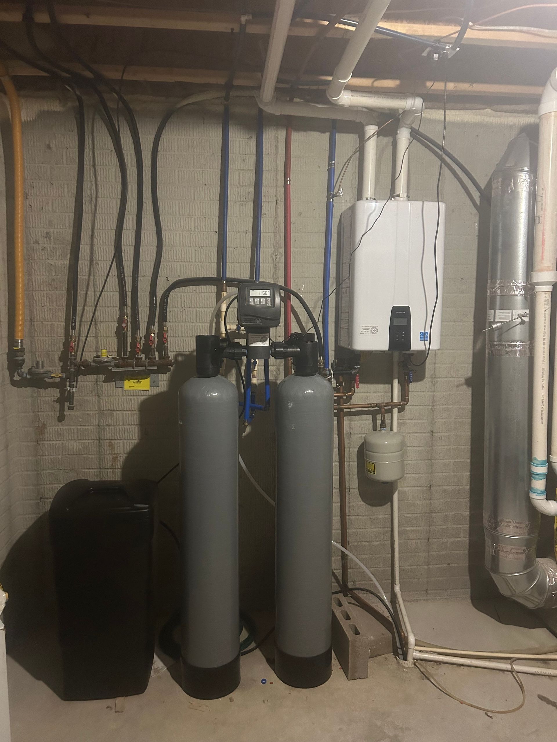 A basement with two water filters and a boiler.