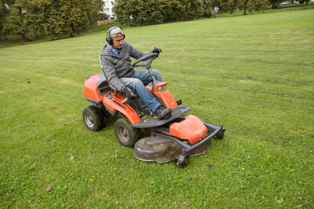 A Yellow Lawn Mower Is Sitting On Top Of A Lush Green Field — Eclipse Hire In  Cairns, QLD
