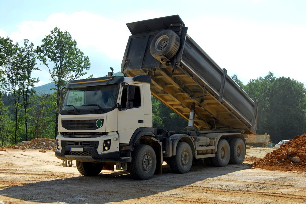A Dump Truck Is Parked In A Dirt Field — Eclipse Hire In Tablelands, QLD