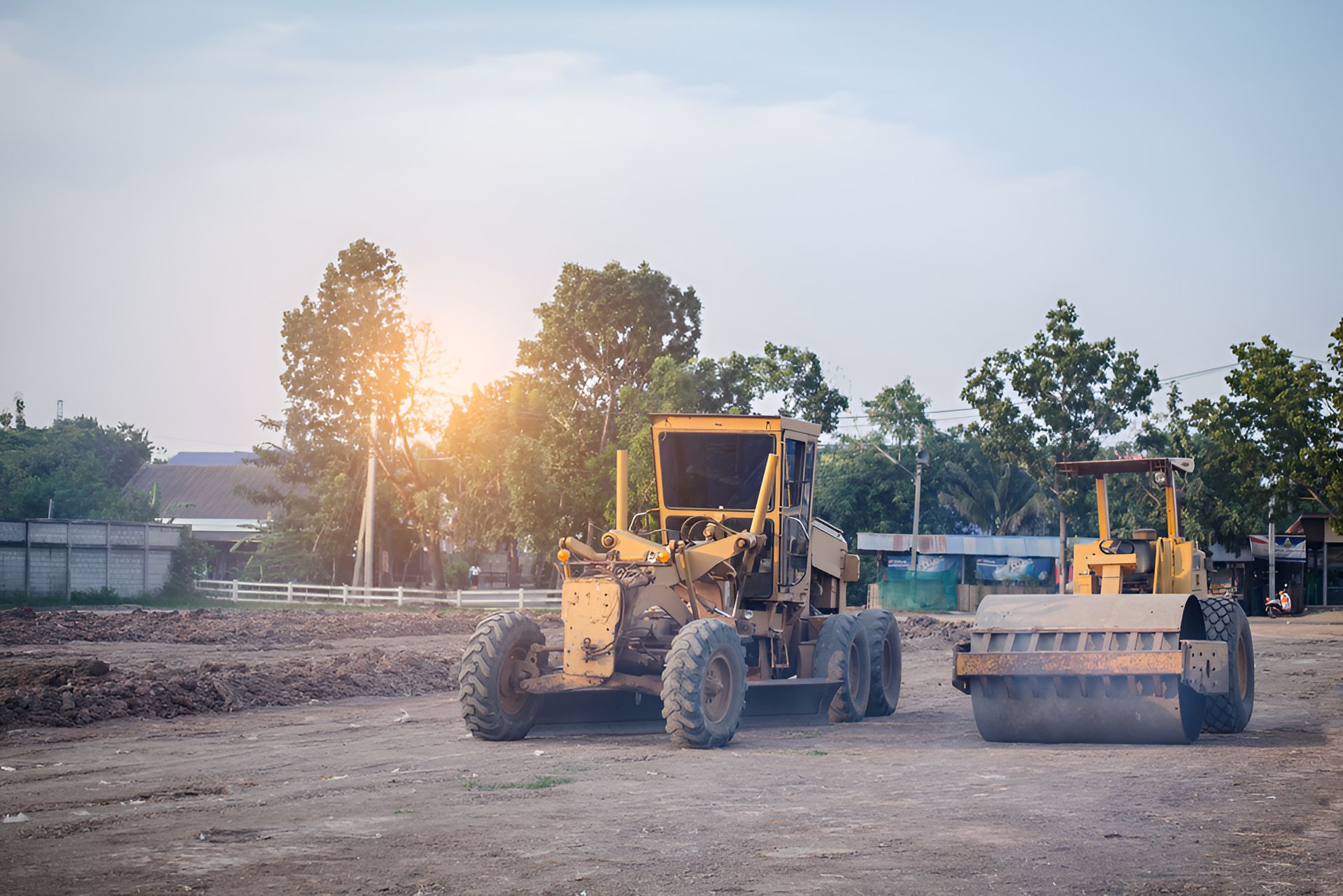 TWo Construction Vehicles Are Parked In A Dirt Field — Eclipse Hire In Tablelands, QLD
