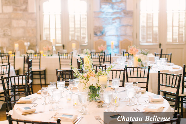 A room with tables and chairs set up for a wedding reception.