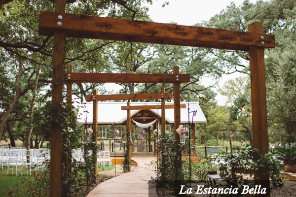 A wooden archway leads to a building called la estancia bella