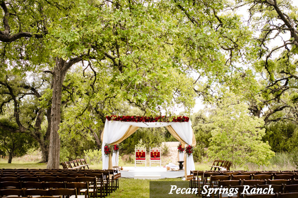 A wedding ceremony is taking place in the woods at pecan springs ranch.