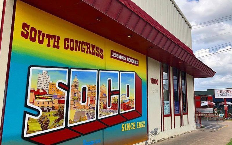 A building with a mural on the side that says south congress