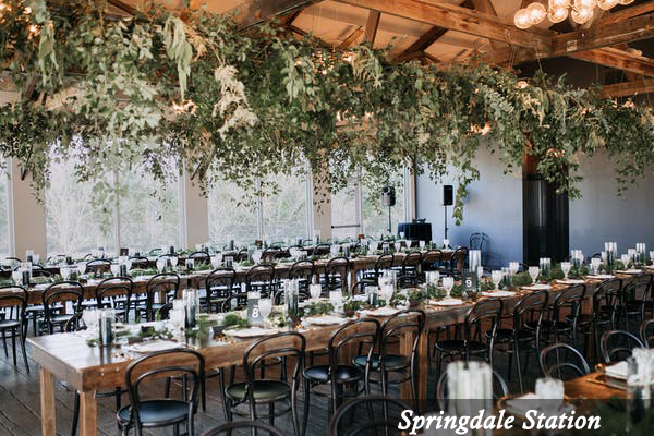 A large room with tables and chairs set up for a wedding reception.