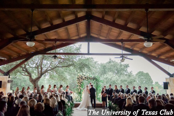 A bride and groom are kissing during their wedding ceremony at the university of texas club