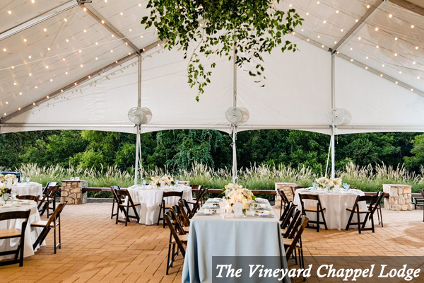 Tables and chairs under a tent at the vineyard chappel lodge