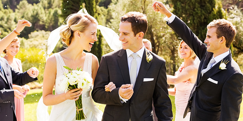A bride and groom are walking down the aisle with their wedding party.