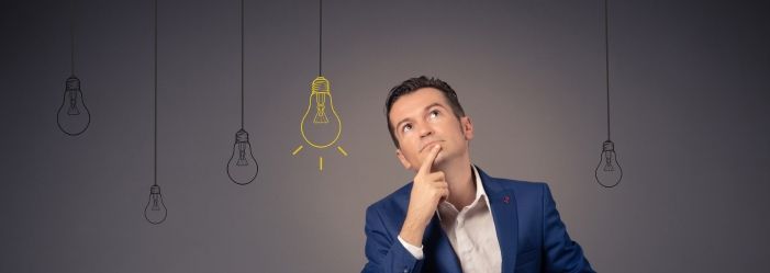 A man in a suit is sitting in front of a wall with light bulbs drawn on it thinking of what happens to a credit card debt after 7 years.