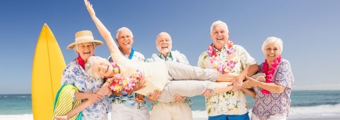 A group of elderly people are posing for a picture on the beach as a sign of Securing Your Golden Years