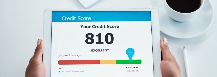 A person is holding a tablet with a credit score of 810 emphasizing the importance of Improving Your Credit Score.