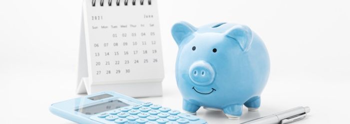 A piggy bank next to a calculator and a calendar emphasizes the Retirement Saving Goals and Tips.